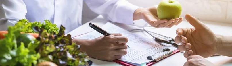 Mãos a escrever e segurar maçã verde sobre mesa com salada — Consultas