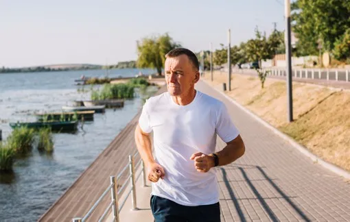 Homem a correr numa passadeira ao ar livre — Exercício Físico