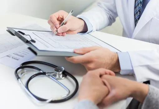 Médico escreve numa prancheta com estetoscópio na mesa — Uretrite