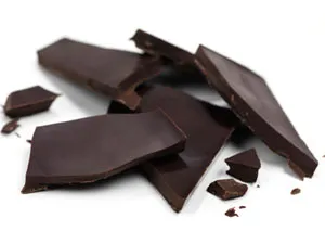 Pedaços de chocolate escuro sobre fundo branco — 10 alimentos que melhoram a saúde e a potência