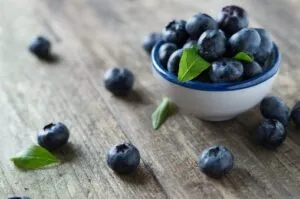 Frutos vermelhos num prato branco sobre mesa de madeira — Alzheimer – é possível evitar?